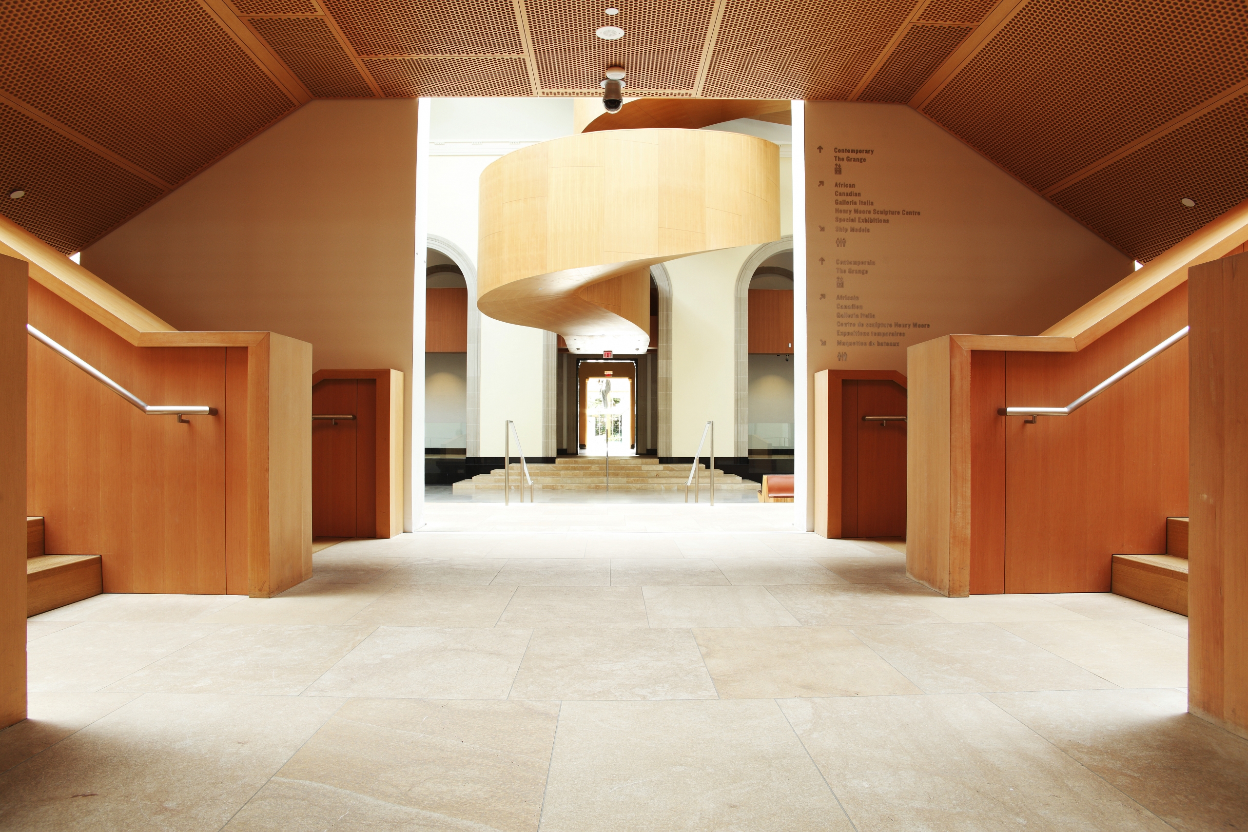 The inviting lobby interior of the Art Gallery of Ontario with winding staircase.