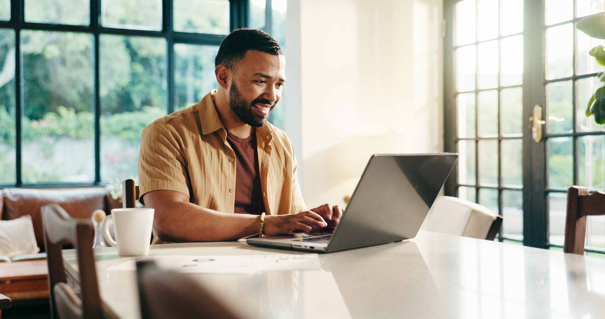 Laptop, typing and happy man in home office for hybrid work, finance and positive cashflow. Computer, freelancer and reading email online for accounting, bookkeeping and revenue growth for investment.