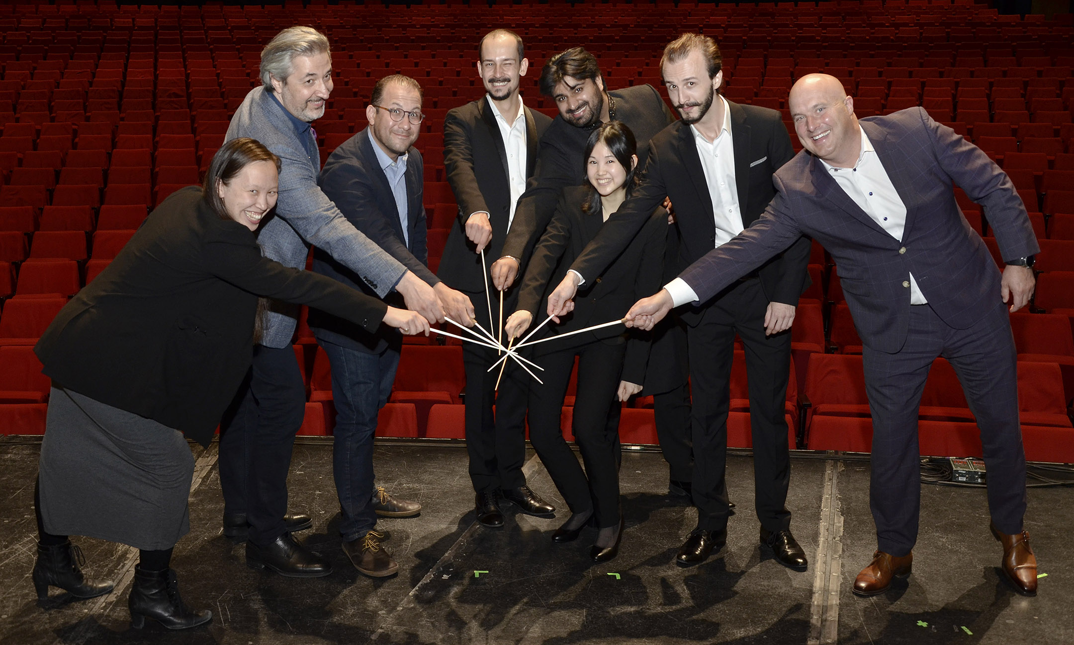 Naomi Woo and other conductors from the RBC Conductors Showcase, with their batons in a circle