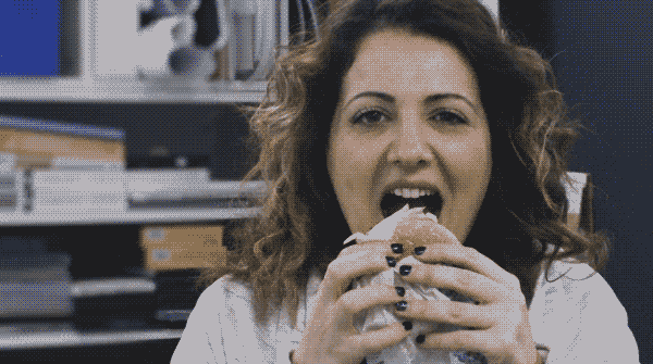 Girl biting into hamburger.