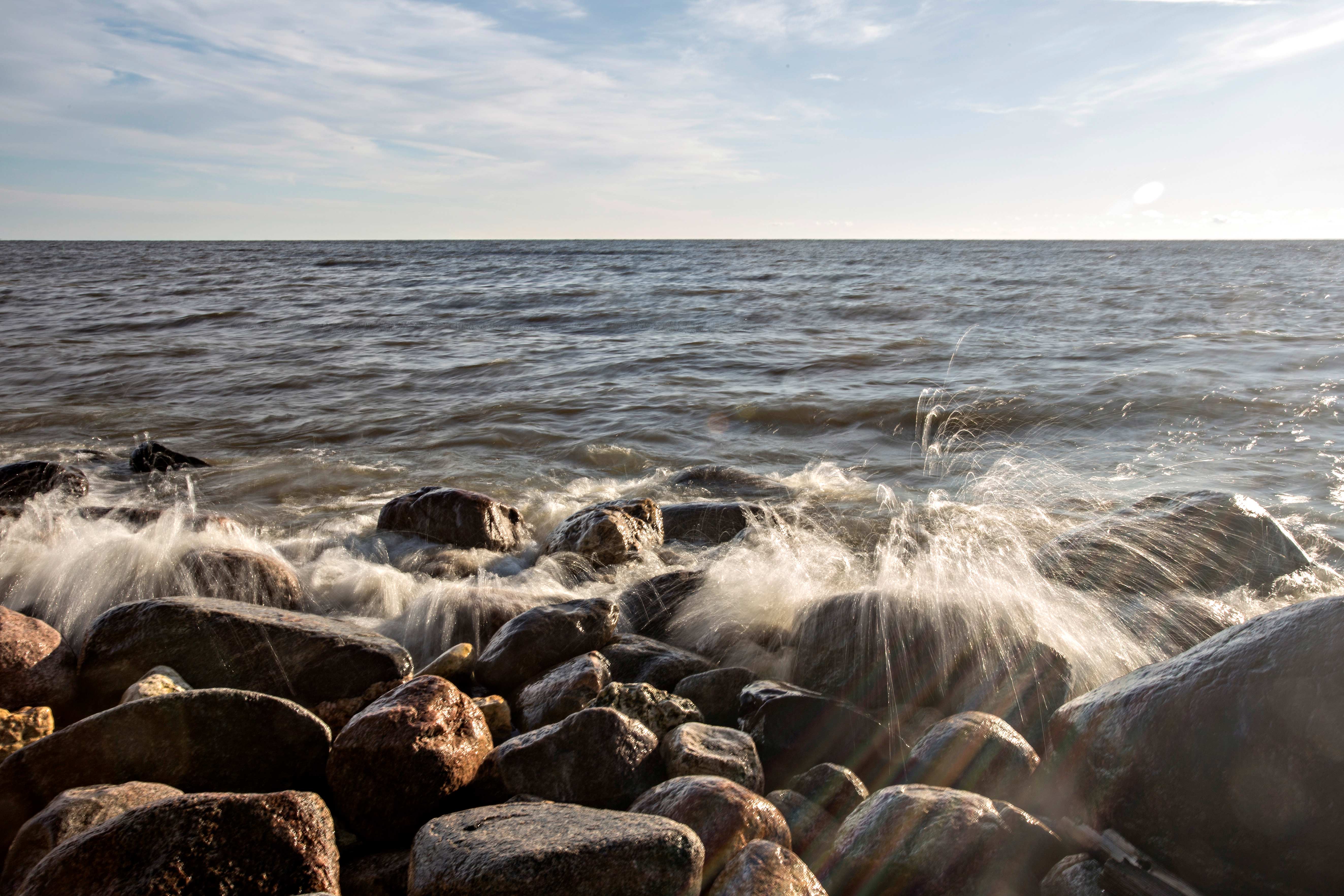 Water splashes over rocks at the shore of Lake Winnipeg.