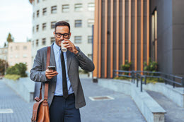 A man drinking coffee on the road.