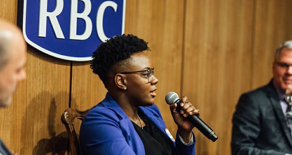 Ketty Cédat speaking into microphone at an RBC event