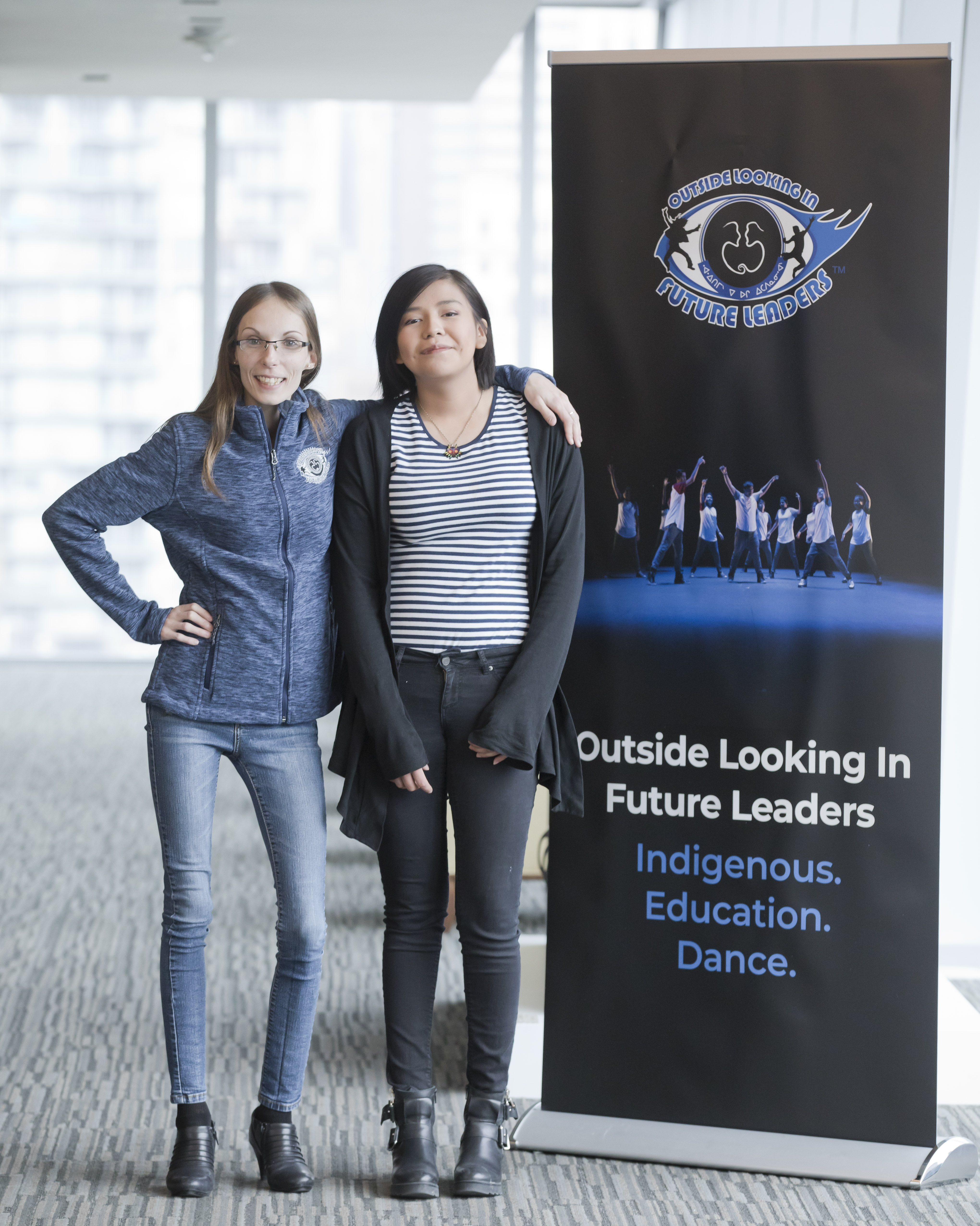 Bobbie-Jane Langdon and Estelle Quilla stand before an OLI banner.