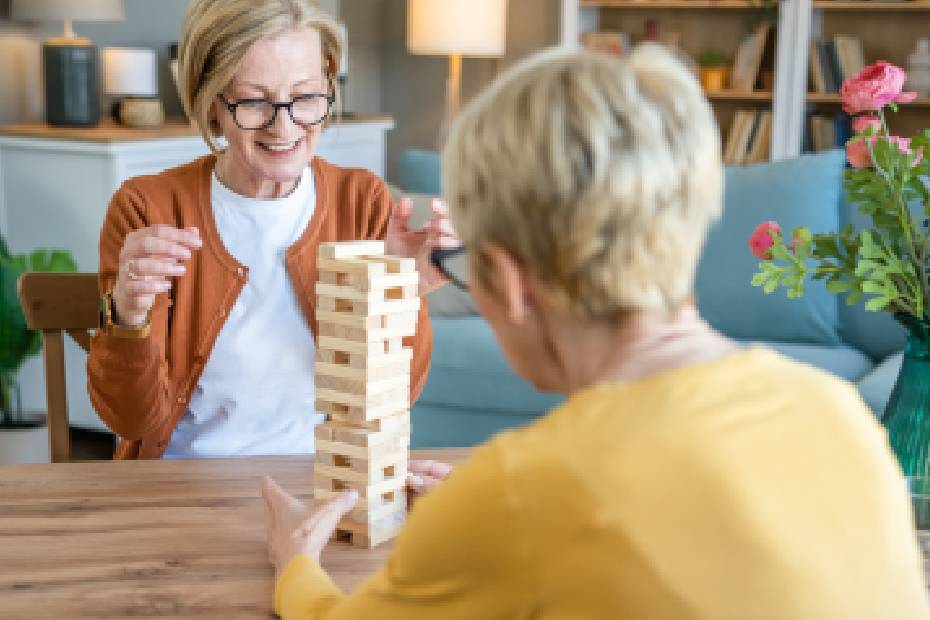 Women playing a game of balancing wooden blocks