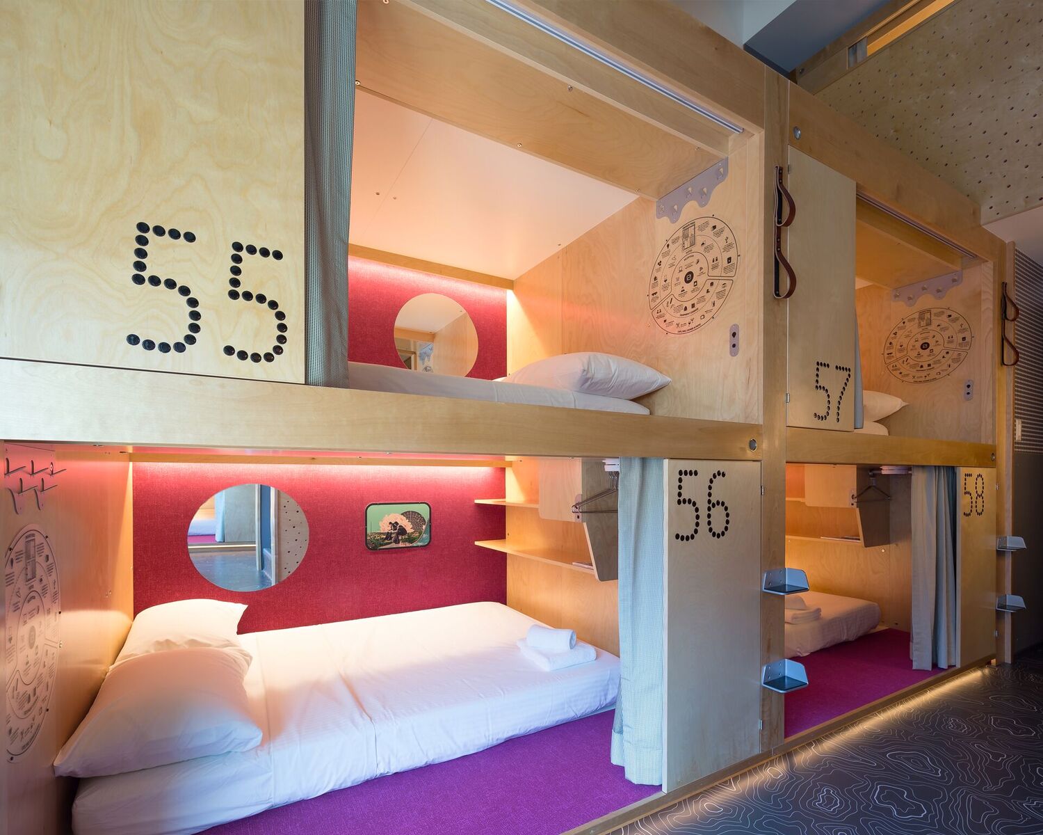Suite-entry pods numbered 55-58 with purple carpets, double beds with white linens and privacy curtains.