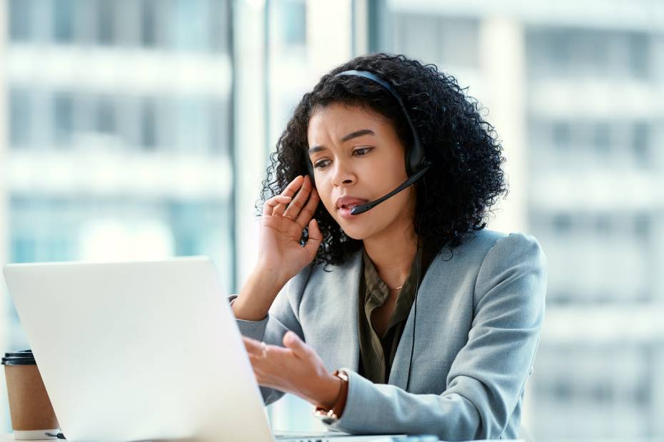 A young business owner in front of her computer, taking a phone call