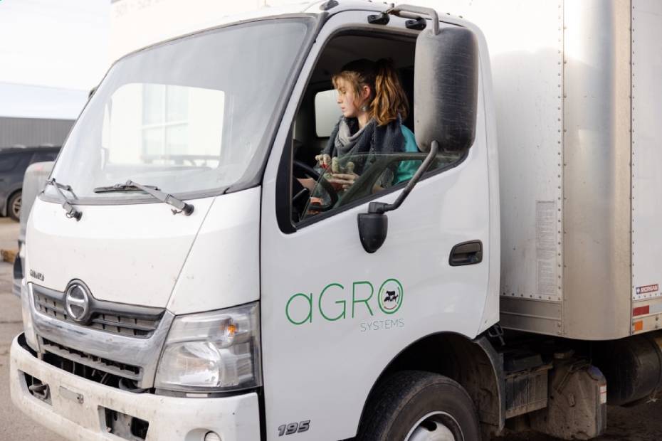 aGRO Systems founder Victoria Ross sitting in the driver's seat of a white truck on a sunny morning