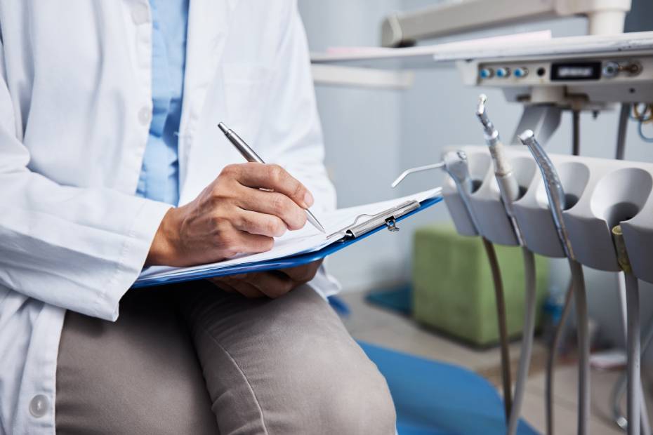 Image of a dentist writing notes in his clinic