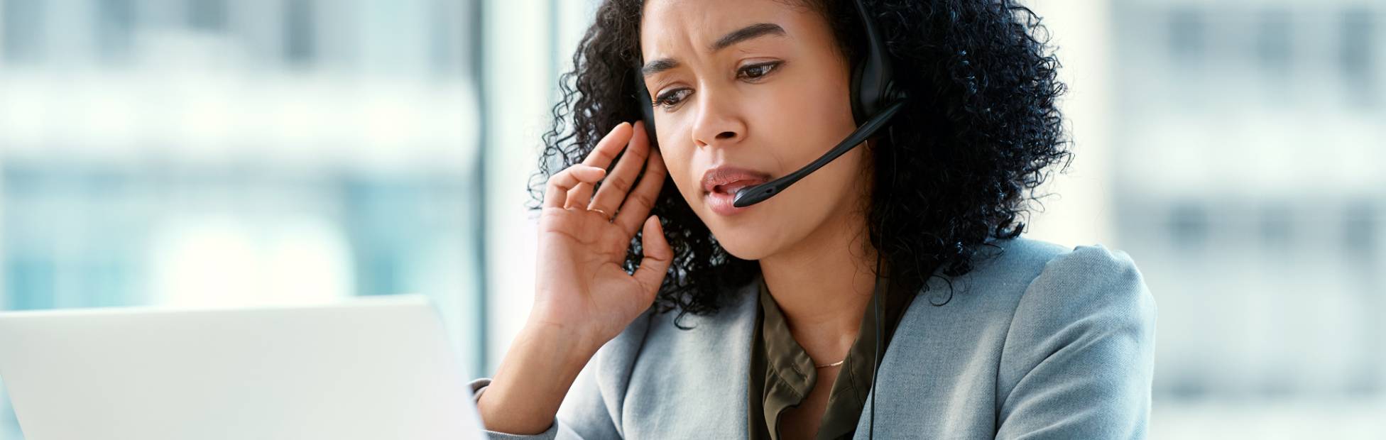 A young business owner in front of her computer, taking a phone call
