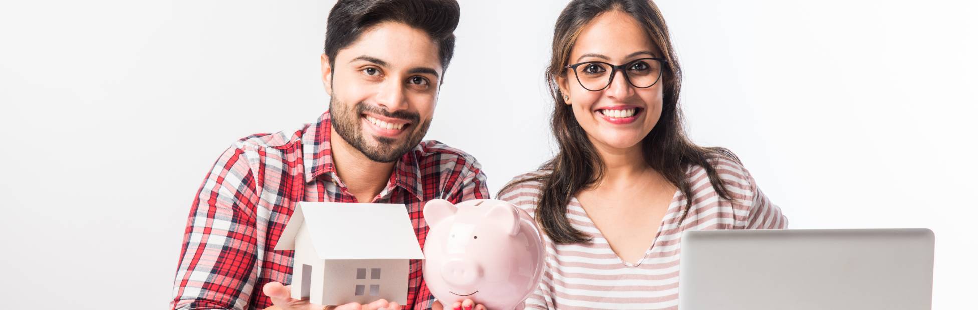 Focused Indian young newcomer couple accounting, calculating bills, discussing planning budget together using online banking services
