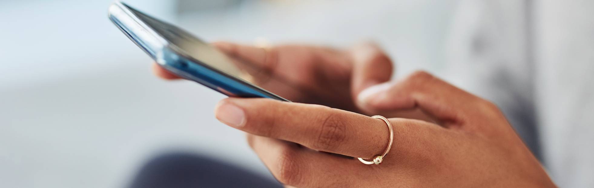 Female hands holding a mobile phone.