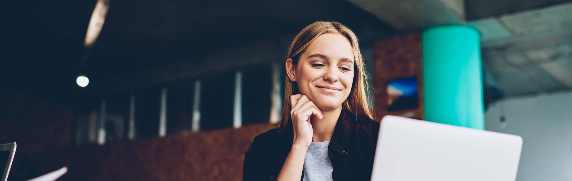 Woman smiling at laptop screen