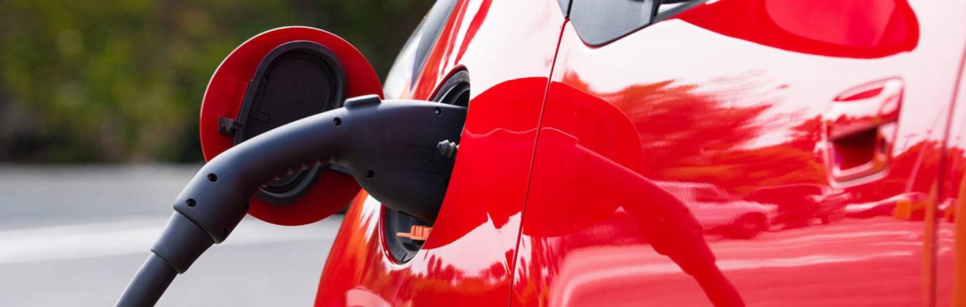 A red car getting gas pumped.