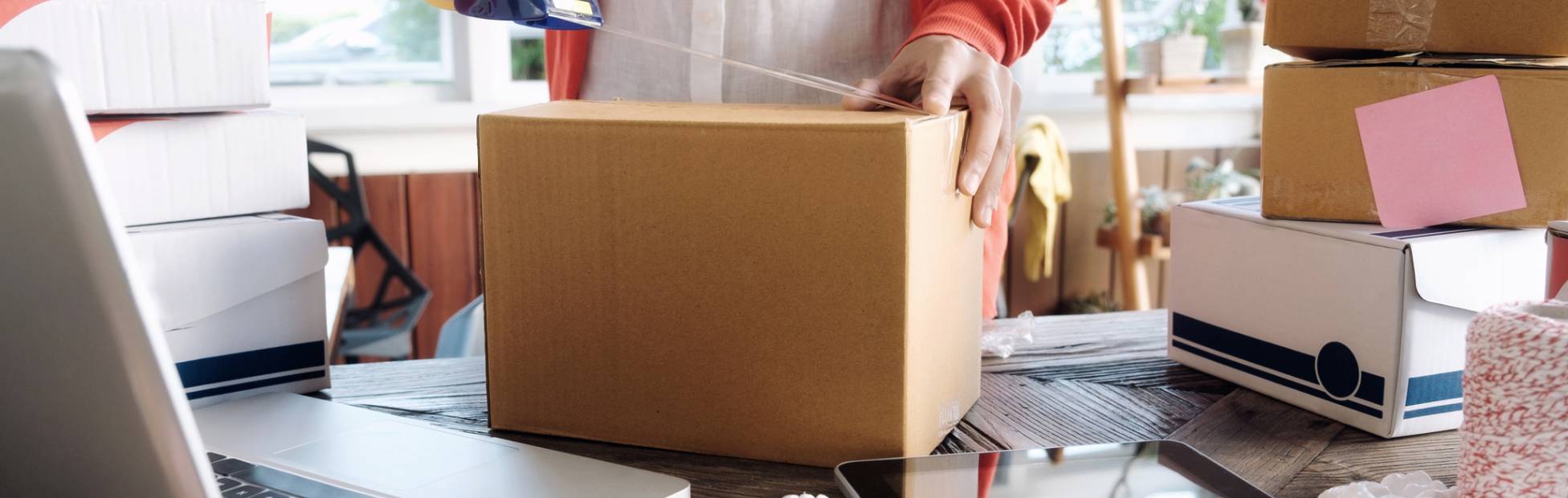 Person packing a cardboard box