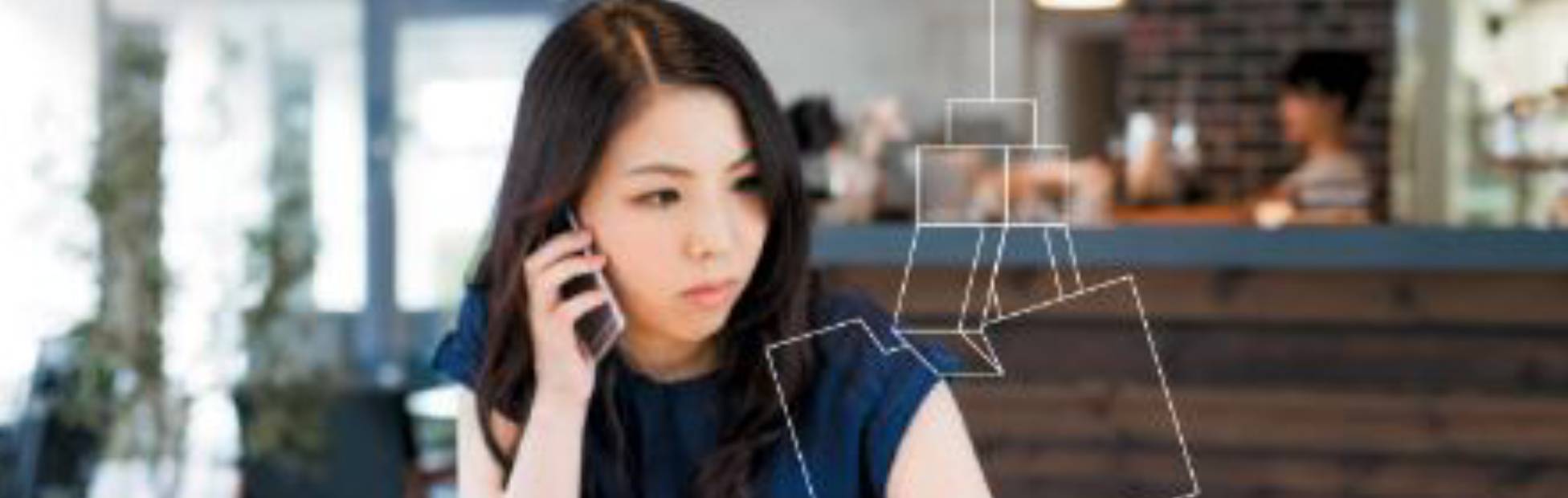 Lady making a call on her phone and also scrolling on her laptop.