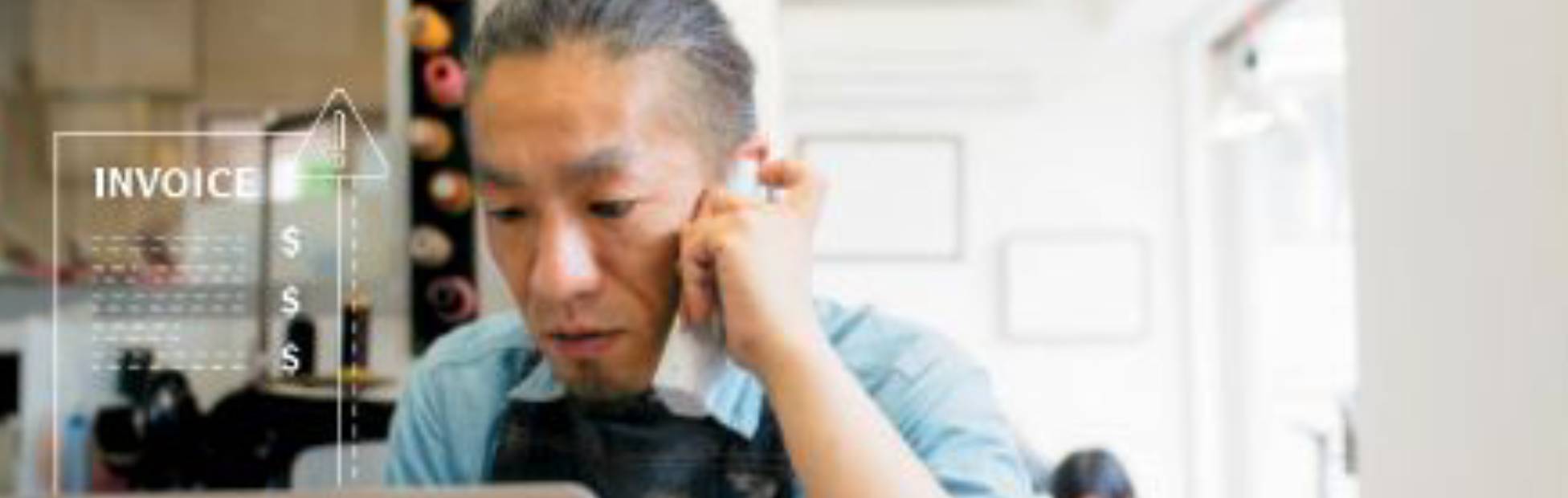 Man making a call on his phone while scrolling on his laptop