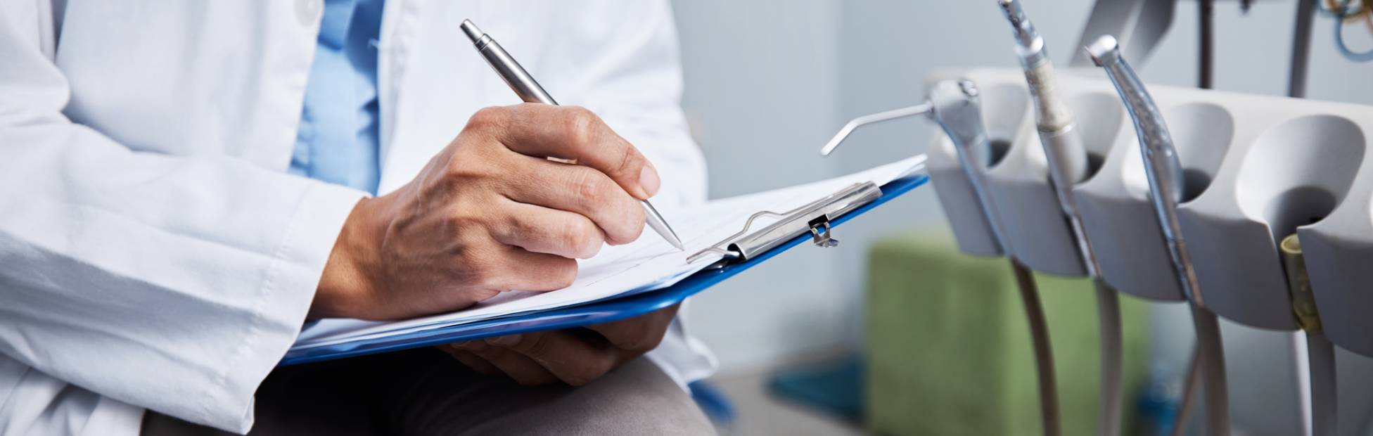 Image of a dentist writing notes in his clinic