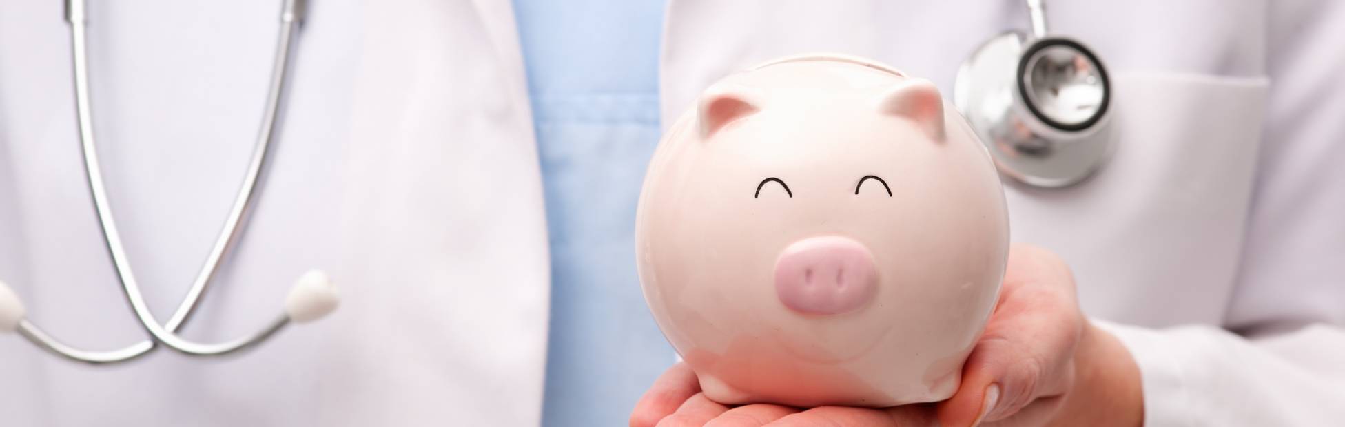 A picture showing a female physician holding a piggy bank on her hand.