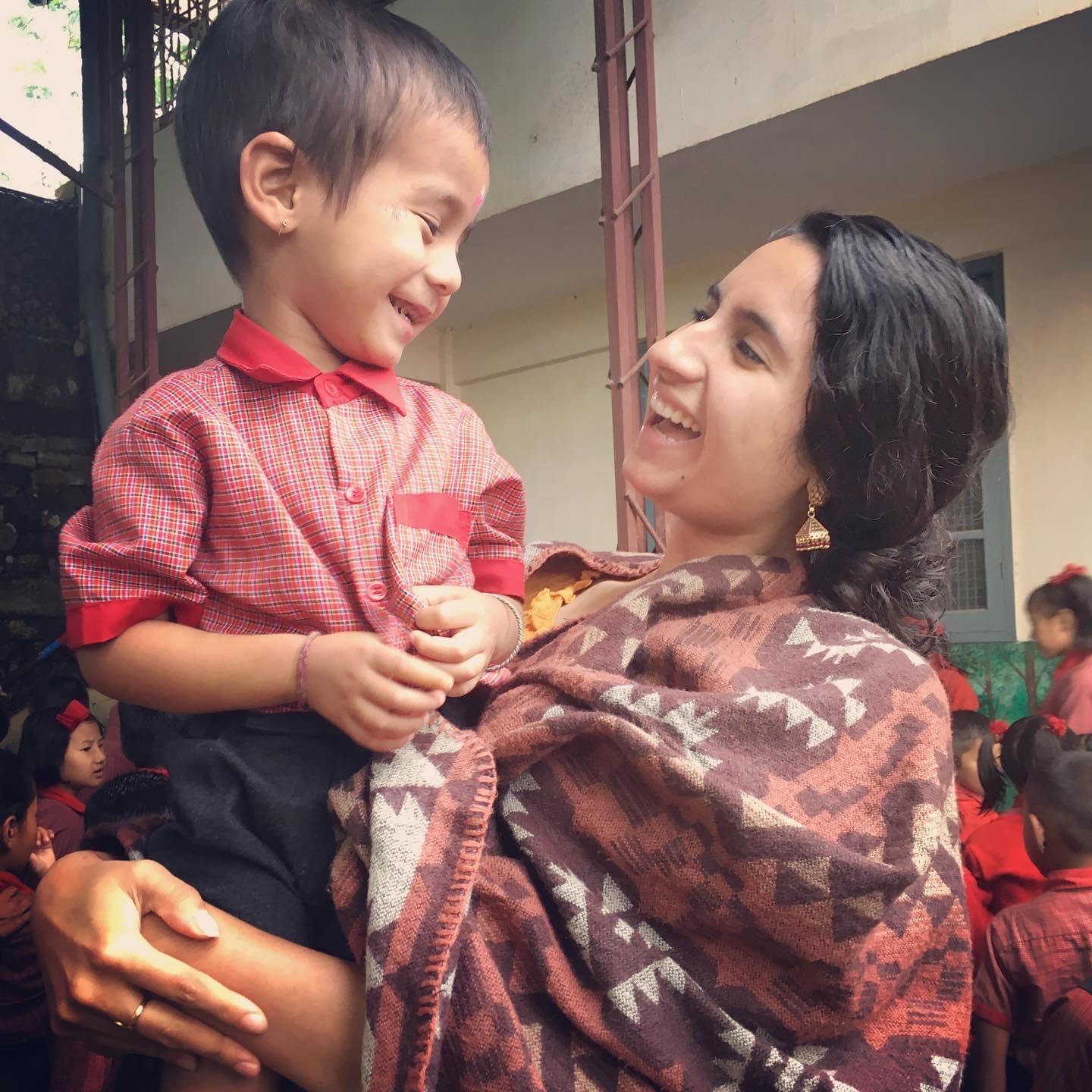 Roshni Thawani holds a smiling young student
