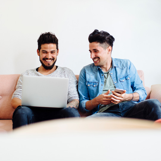 Friends sitting on couch with devices
