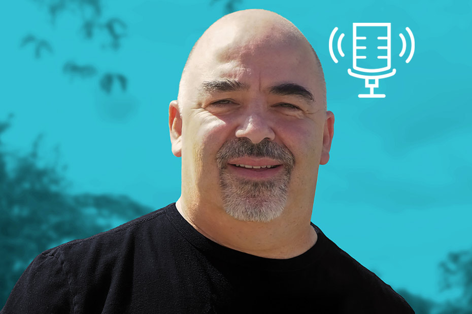 Paul Derry, former career criminal turned author, in a black t-shirt, in front of a blue background, guest on Tony Chapman's Chatter That Matters.