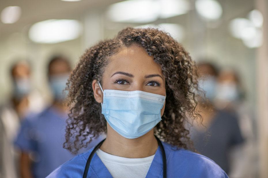 A young doctor standing in front of her colleagues at the hospital.