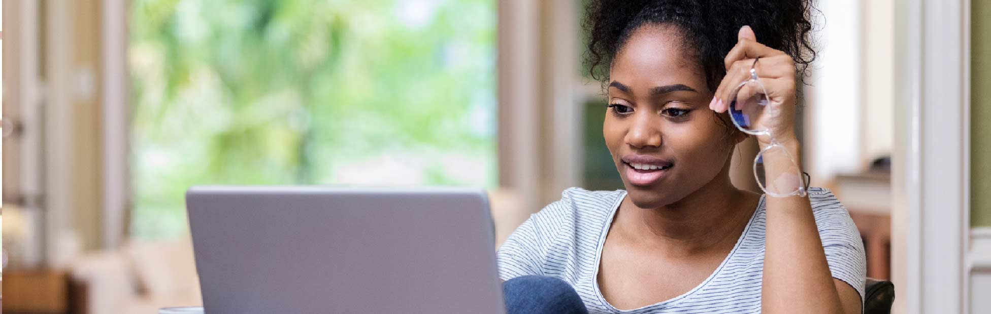 A post-secondary Canadian female student on her laptop looking for ways and options to pay for school — college or university — in Canada.