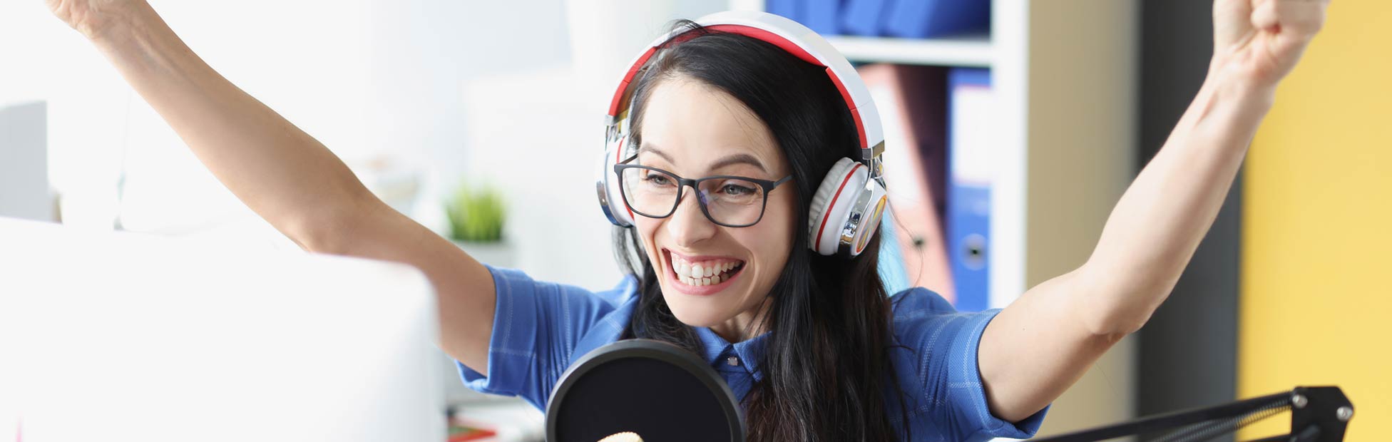 Female podcaster raising her arms in celebration