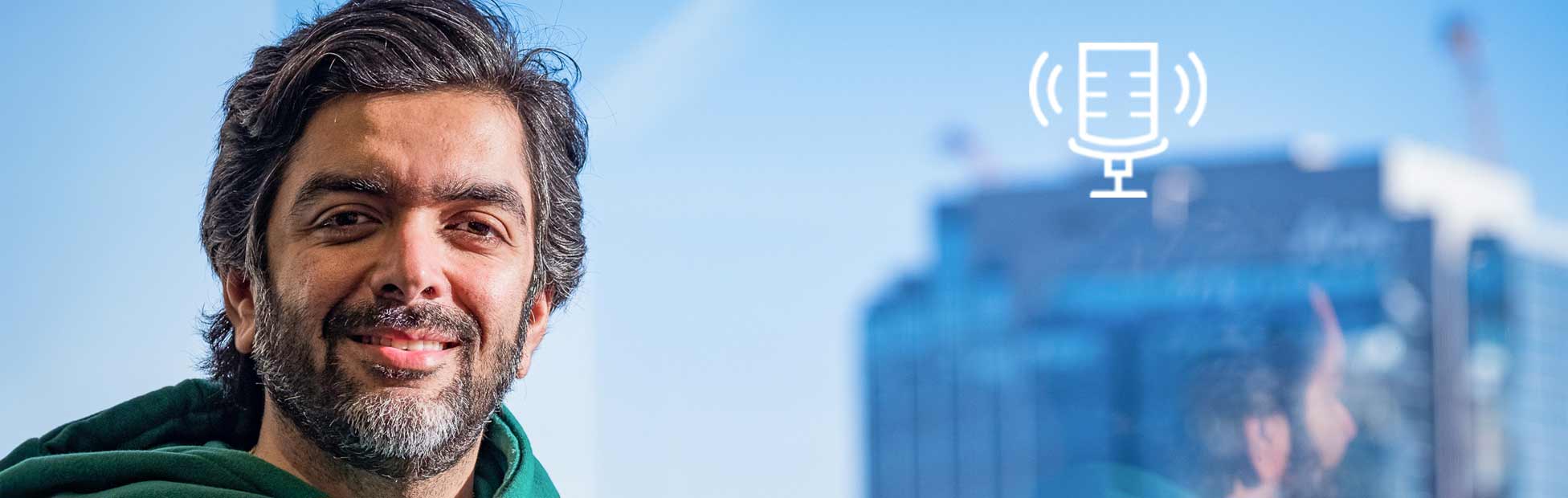 Internet influencer and entrepreneur Avi Arya wearing a green hoodie beside a window in a high-rise building on Tony Chapman's Chatter That Matters.