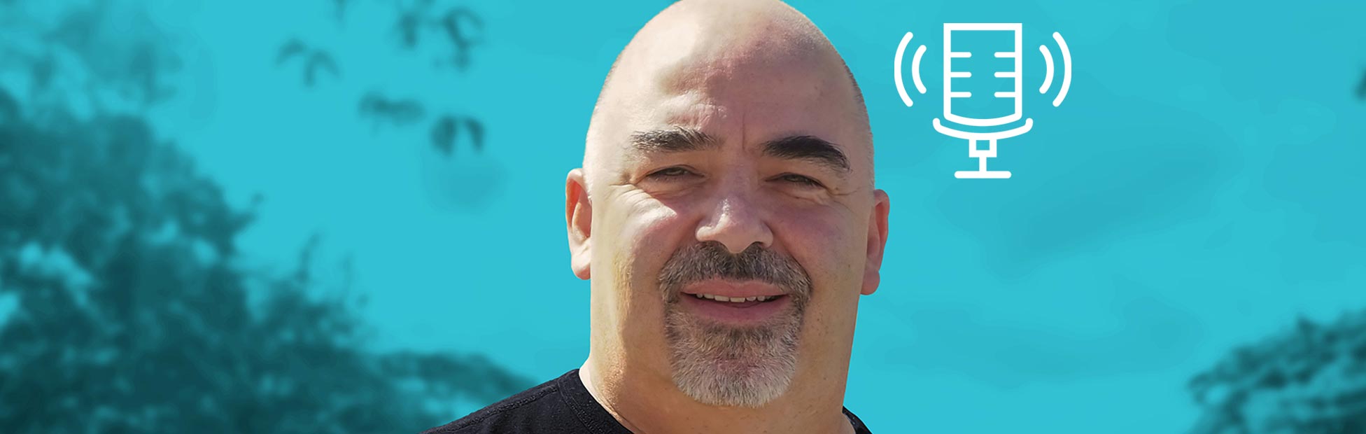 Paul Derry, former career criminal turned author, in a black t-shirt, in front of a blue background, guest on Tony Chapman's Chatter That Matters.