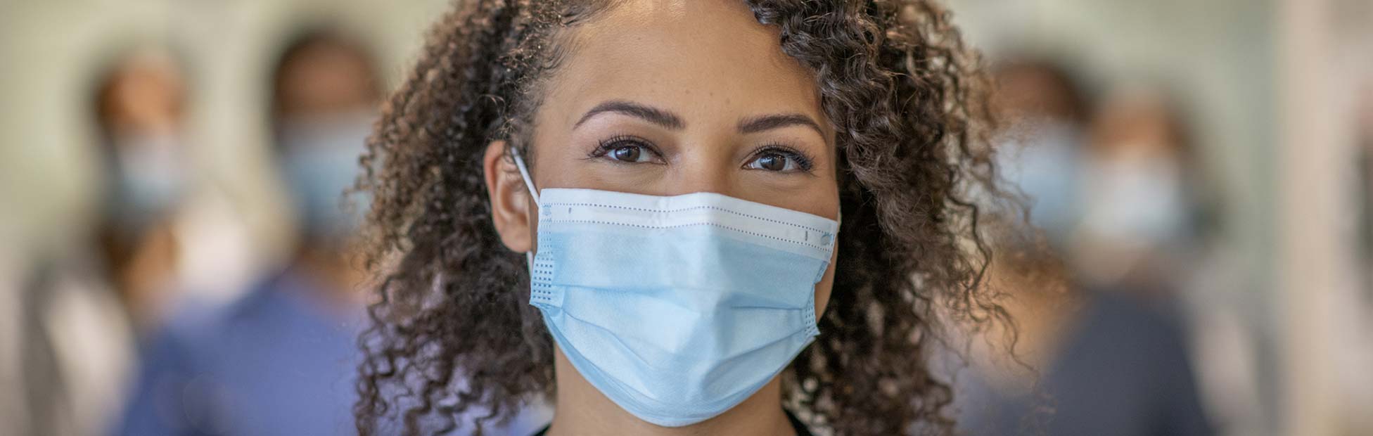 A young doctor standing in front of her colleagues at the hospital.