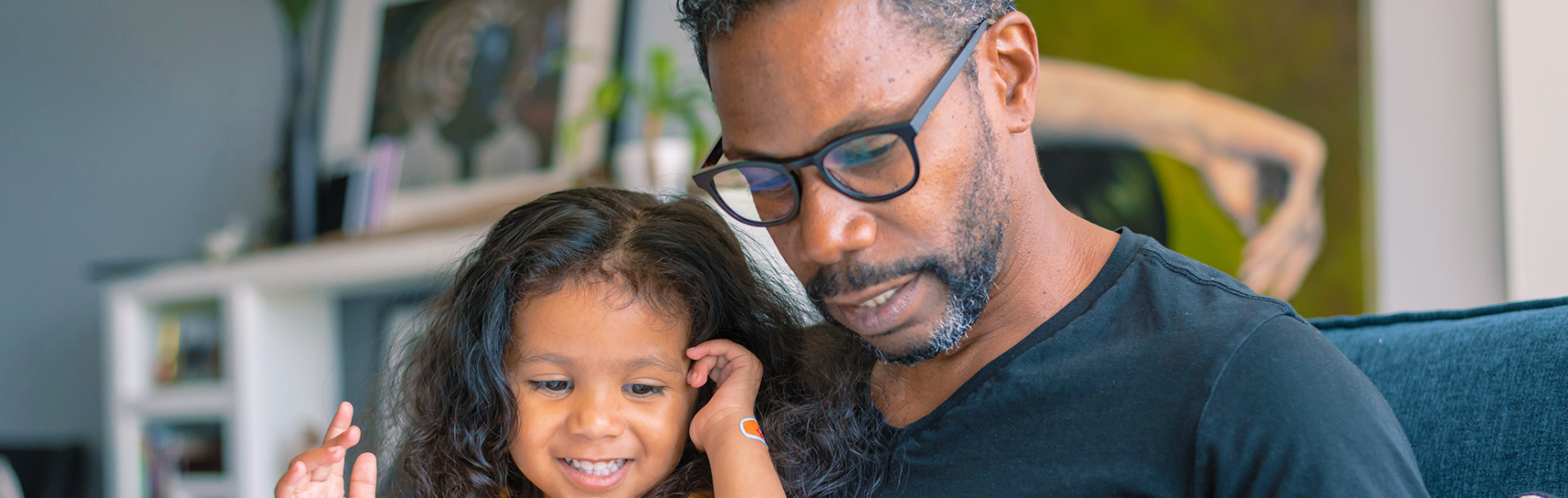 A father reading a book to his daughter