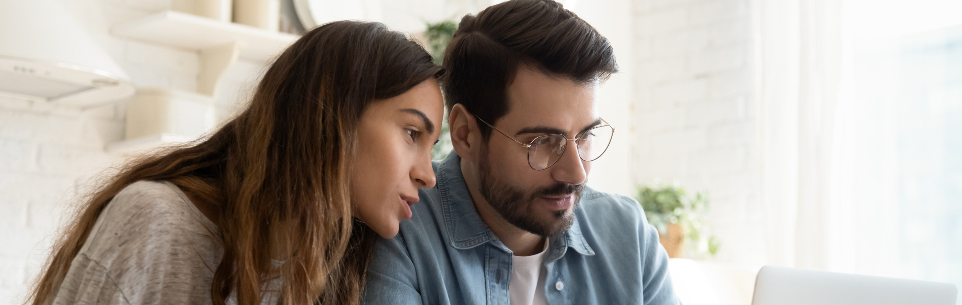 Young couple sitting at a computer looking over their finances together