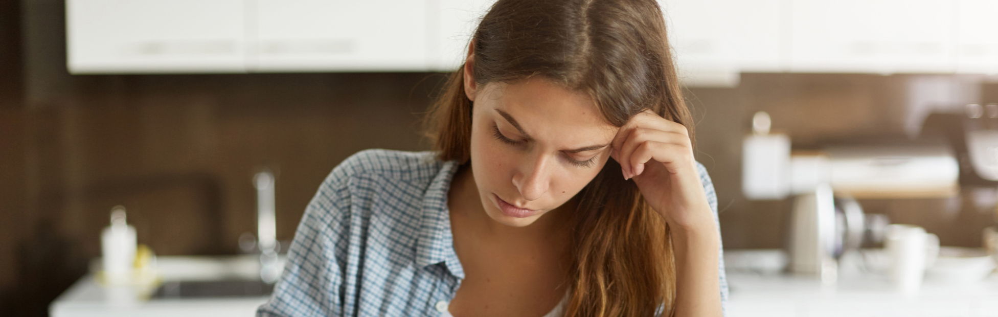 Woman at a desk, stressed about her finances