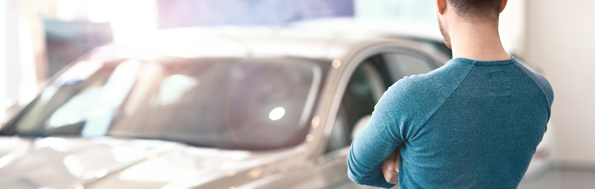 Young man looking at the new car