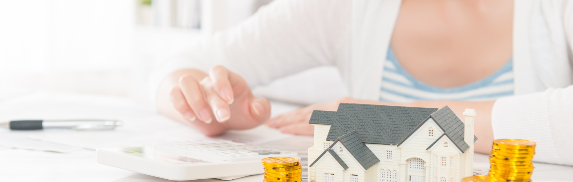 Woman stacking coins on a house