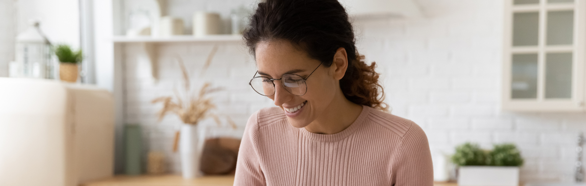 Smiling young latina female at home with financial papers and a calculator