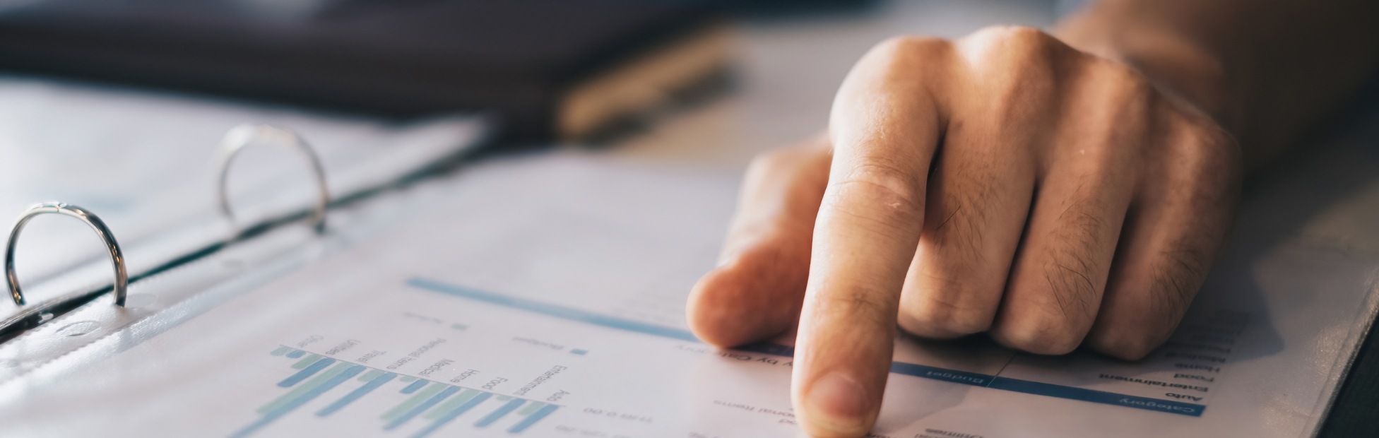 Man out of image at a desk with hand pointing to a pie chart
