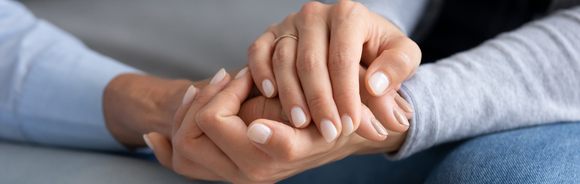 Two people holding hands in a comforting way