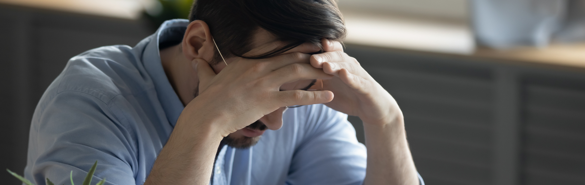 Distressed young Caucasian man sit at desk paying bills