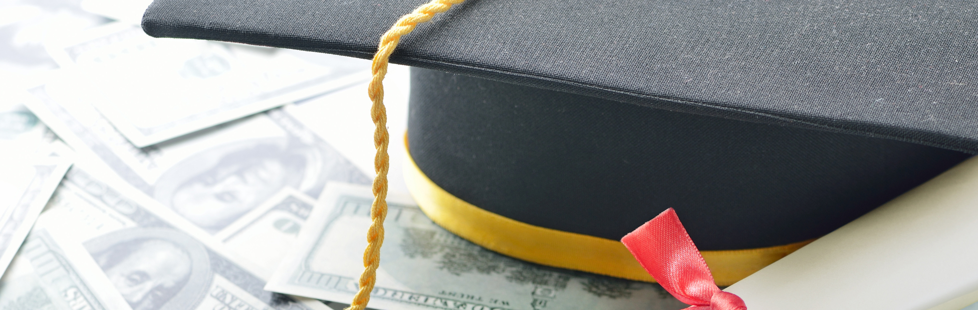 Graduation hat with diploma and US money