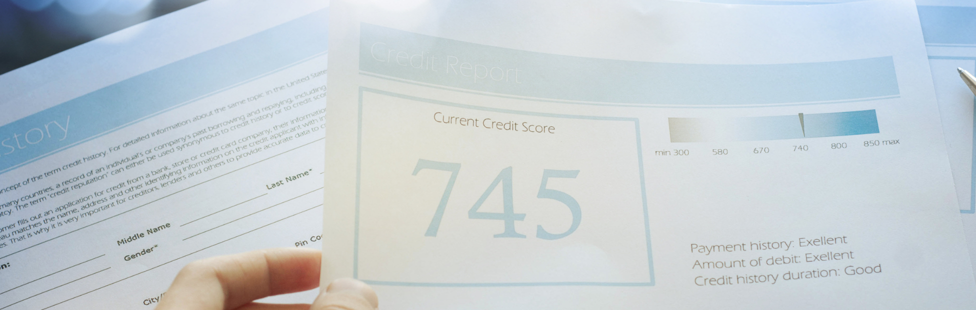 Blurred view of a hand holding their credit report