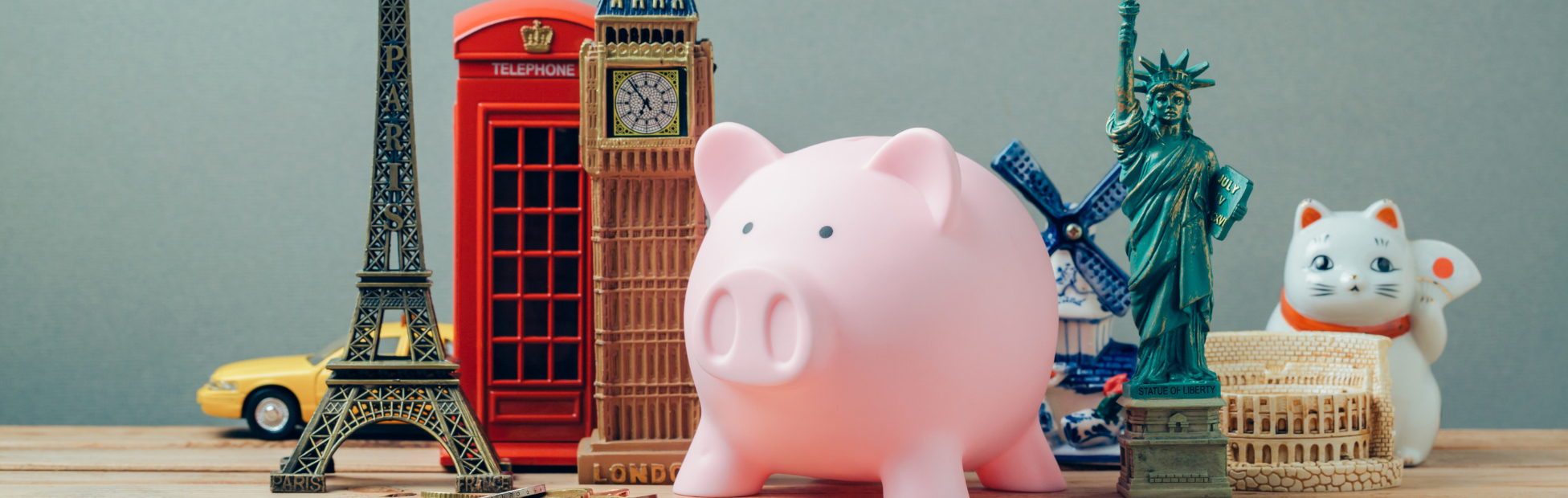 Desk with figurines of Big Ben, Eifel Tower, Statue of Liberty and a piggy bank.