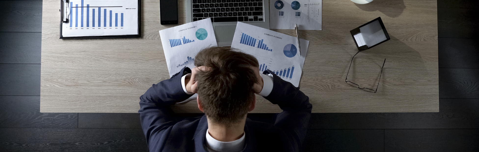 Young man at a desk upset about debt
