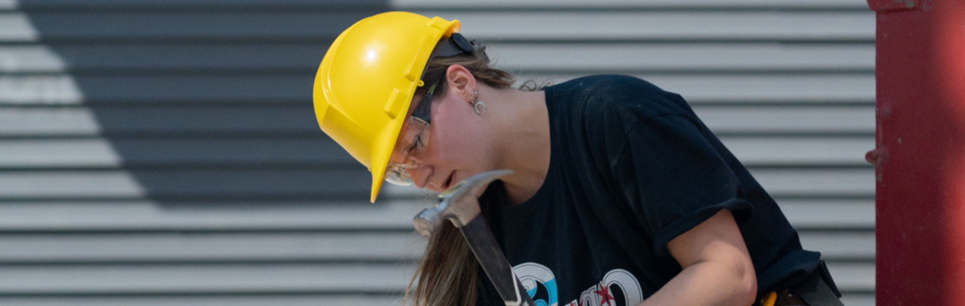 A young female participant hammering nails into a board