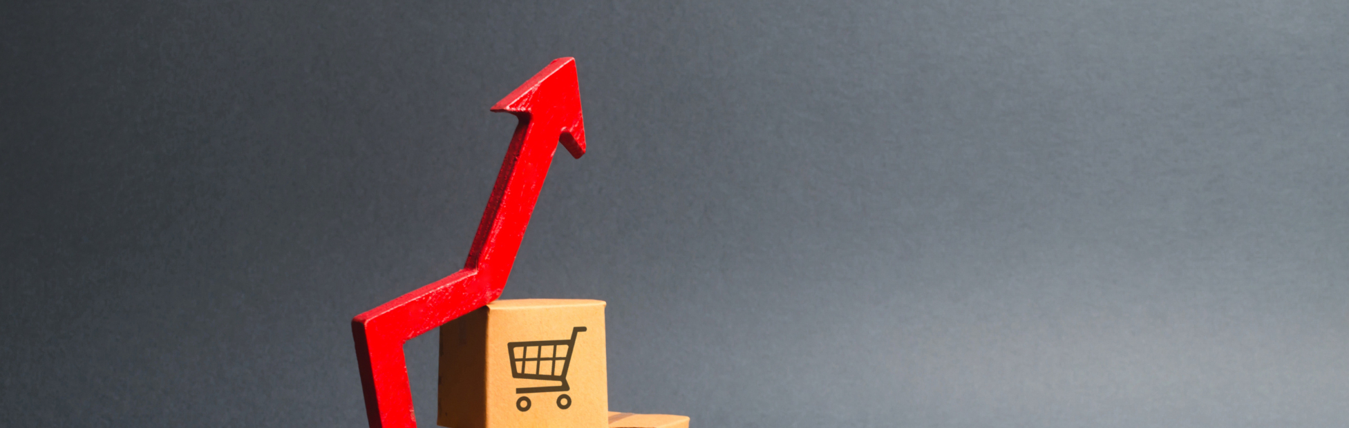 Stack of cardboard shopping boxes and a red up arrow showing rising interest.