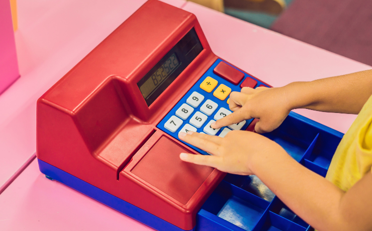 child playing with toy cash register