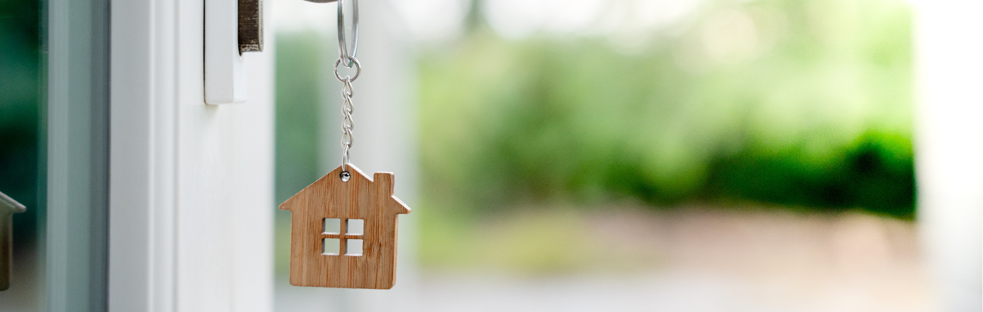 Key to the door with a wooden key ring of a house