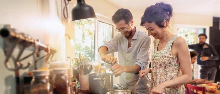 Mixed group of friends have fun while cooking a meal in kitchen